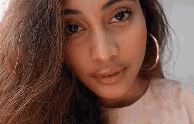 a close up of a woman 's face with hoop earrings on