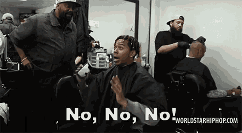 a man is getting his hair cut at a barber shop and says no