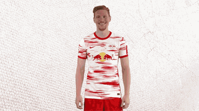 a man wearing a red and white rb leipzig jersey