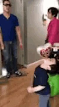 a man in a blue shirt is standing next to a woman in a pink sweater .