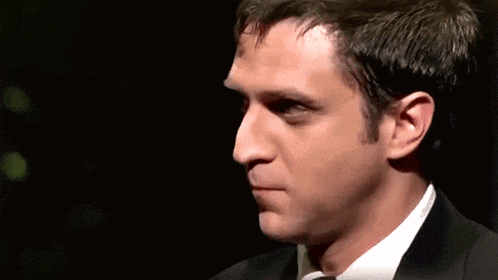 a close up of a man 's face in a suit