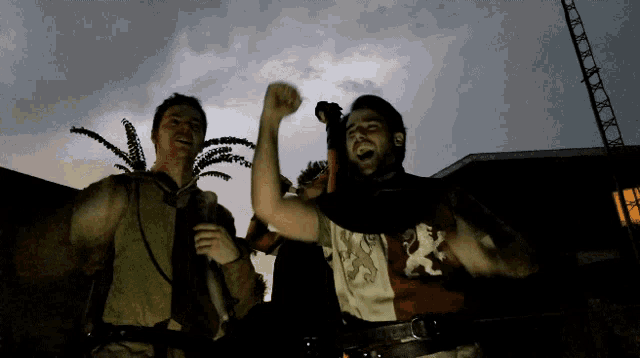a man wearing a shirt with a lion on it holds his fist up in the air