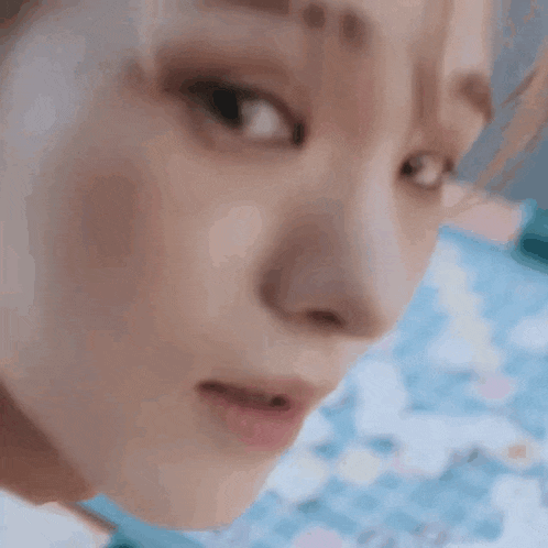 a close up of a woman 's face with a blue background and a pool in the background .