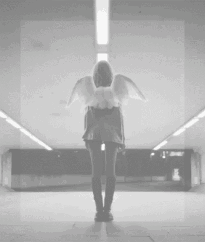 a black and white photo of a woman with angel wings