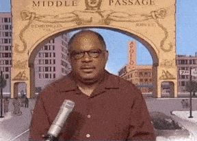 a man in a red shirt stands in front of a sign that says middle passage