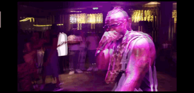 a man singing into a microphone in front of a crowd of people