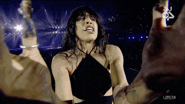 a woman in a black dress is dancing on a stage with the word london on the bottom left