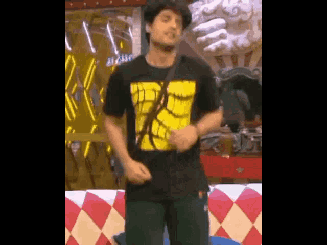 a man in a black shirt with a yellow design on it is dancing
