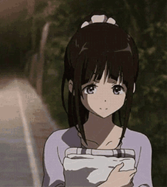 a girl in a ponytail is holding a piece of paper in her hand .