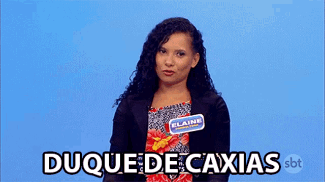 a woman with a name tag that says elaine stands in front of a blue background