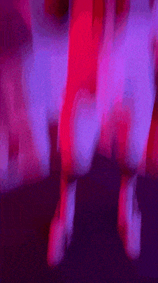 a blurry picture of a person 's legs in a red and purple light