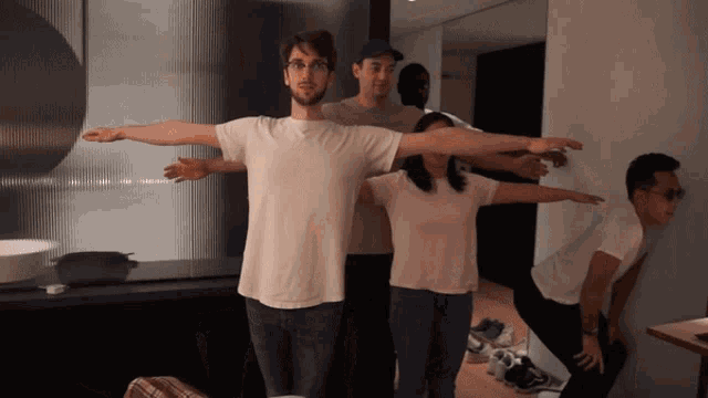 a group of people with their arms outstretched standing next to each other