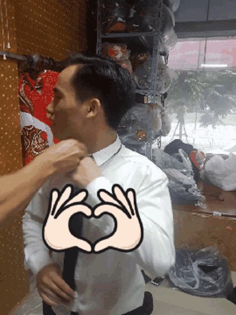 a man in a white shirt and tie is getting his tie adjusted