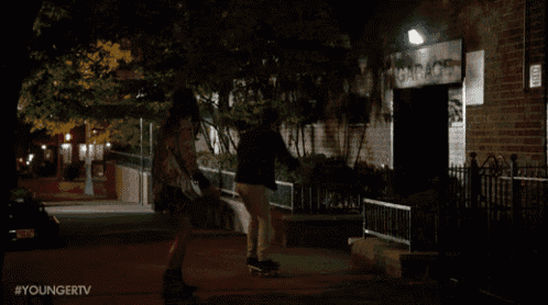 a person riding a skateboard in front of a building that says ' youngertv ' on the bottom