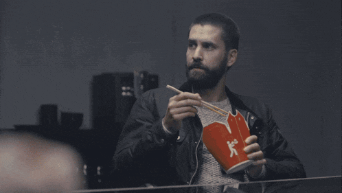 a man with a beard is holding a red box that says coca cola on it