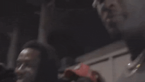 a man wearing a baseball cap with the letter f on it is holding a gun in his hand .