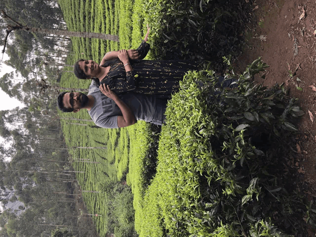 a man and a woman are posing for a picture in a field of plants
