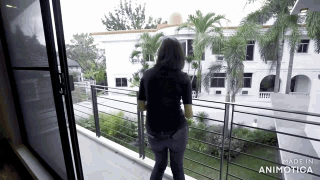a woman standing on a balcony with the words made in animotica on the bottom right
