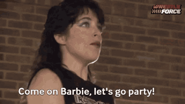 a woman is standing in front of a brick wall and talking to another woman .