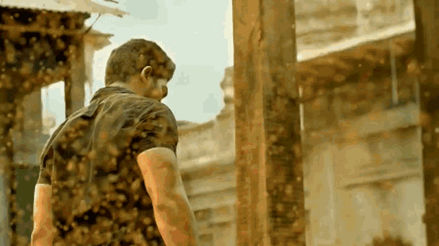 a man standing in front of a building surrounded by bees