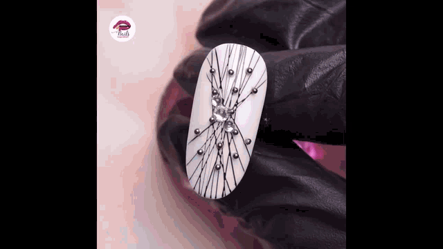 a close up of a person holding a nail with a spider web design on it .