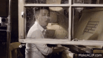 a man in a white shirt and tie is looking out of a window with a sign that says fiat on it