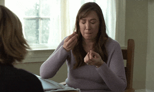 a woman in a purple sweater sits at a table with another woman