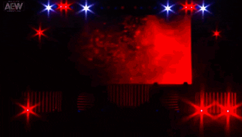 a person is standing in a dark room with a red and purple light behind them .