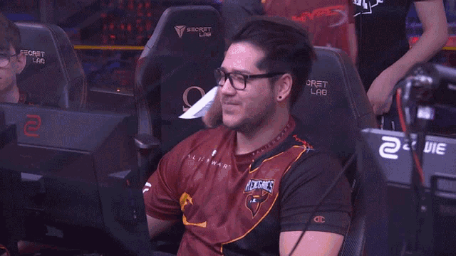 a man wearing glasses and a jersey that says hawks on it