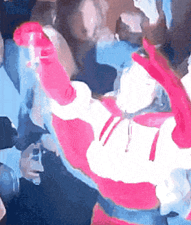 a person in a pink and white costume is holding a red object in their hand .