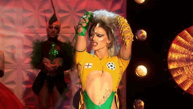 a drag queen wearing a yellow and green outfit with a soccer logo on it