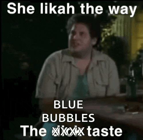 a man is sitting at a table with a caption that says she like the way blue bubbles the xxx taste
