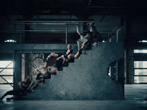 a group of people are standing on a set of concrete steps