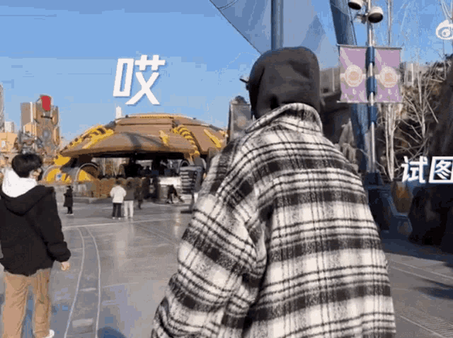 a man in a plaid jacket stands in front of a sign that says ' chinese ' on it
