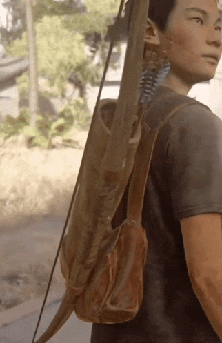 a man carrying a bow and arrow in a brown leather bag