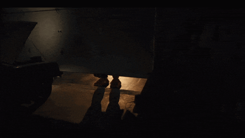a person standing in a dark room with a light shining on their feet