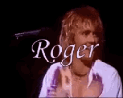 a man is standing in front of a black background with the word roger written on it .