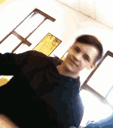 a young man taking a selfie in a room with a map on the wall