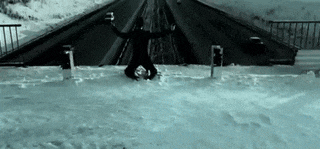 a person is doing a handstand in the snow on a bridge