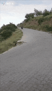 a person riding a motorcycle down a road with a tiktok watermark