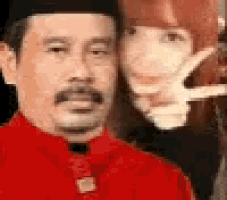 a man in a red shirt and hat is standing next to a woman in a red shirt .