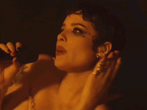 a woman is singing into a microphone with a bandage on her arm