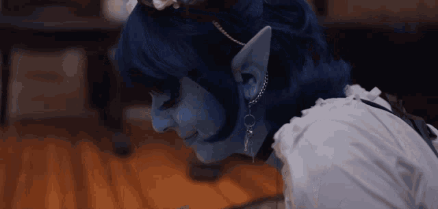 a close up of a person with blue hair and earrings