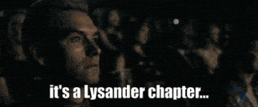 a man is sitting in a theater watching a movie and the words it 's a lysander chapter are above him