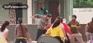 a group of people are dancing in front of a mirror in a room .