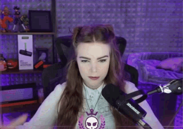 a girl is sitting in front of a shure microphone .