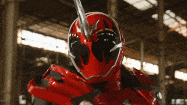 a man in a red helmet holds a sword in his hand