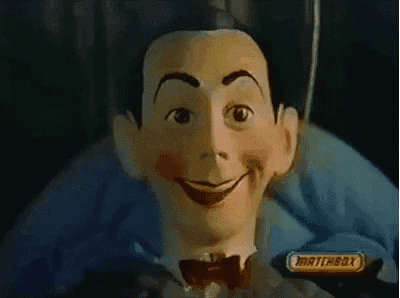 a close up of a puppet with a bow tie and a matchbox logo in the background .
