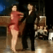 a man and woman are dancing on a dance floor .