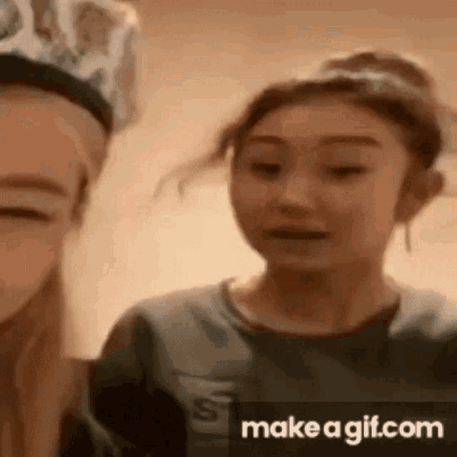 a couple of girls are standing next to each other and looking at the camera .